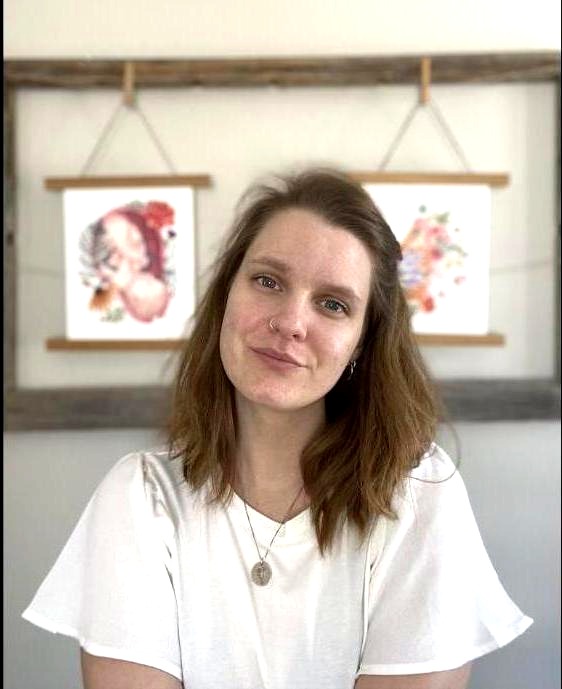 Alice, accompagnante périnatale, souriante devant ses illustrations de naissance